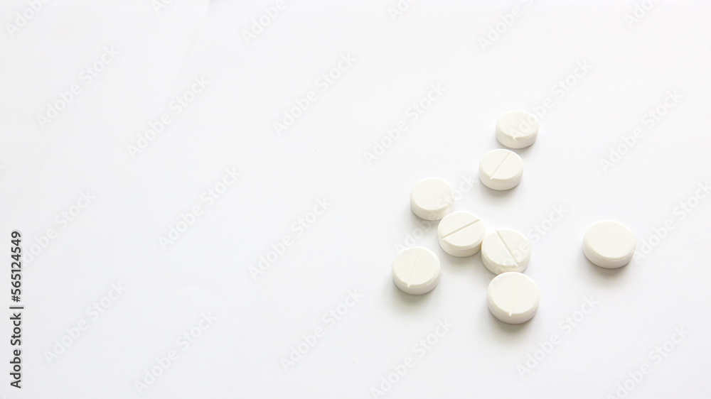 Assorted scattered pharmaceutical medicine white tablets isolated in white background, copy space for text or advertising