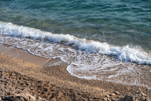 Fototapeta Naklejka Na Ścianę i Meble -  Waves splashing sand beach of Brac island, Croatia during beautiful summer sunset creating white foam