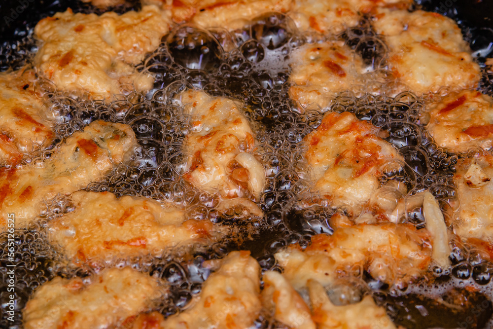 Fry the chicken pieces in a frying pan with oil. Fried meat in an egg.