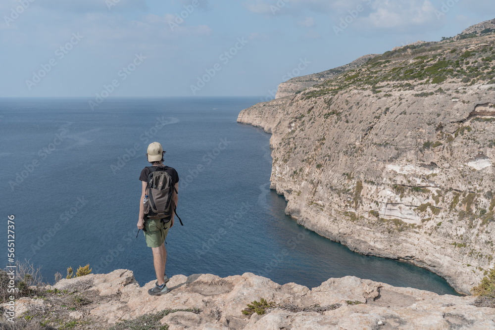 Man standing on the cliff watching the sea on a sunny summer day in Malta