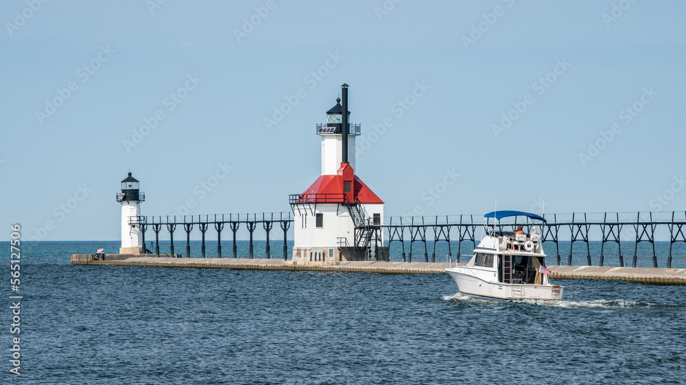 A boat heads out into Lake Michigan next to the St. Joseph North Pier Outer and Inner lighthouses. A boat heads out into Lake Michigan next to the St. Joseph North Pier Outer and Inner lighthouses.