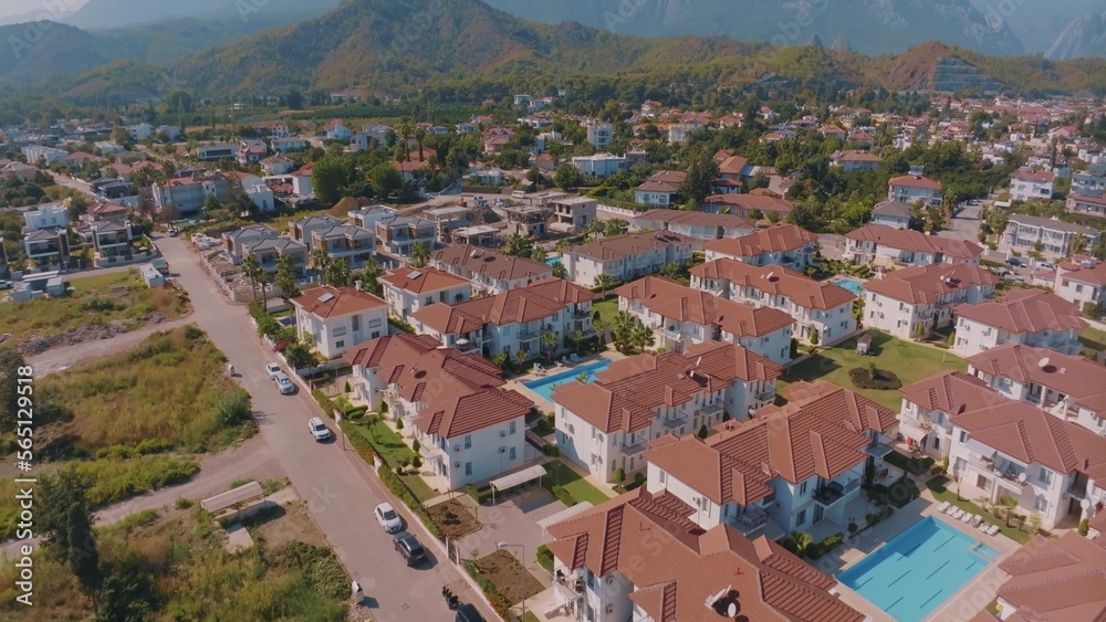 Aerial panorama of small resort town. Hotels, houses and roads. Green hills around. Mountain landscape. Photography