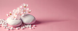 White stones with blossom flowers on pink background. Panoramic banner background with copy space.