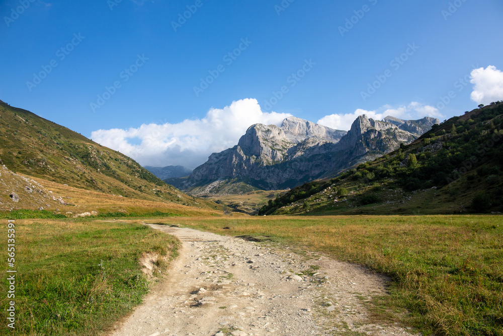 A valley in the mountains with a dirt road. A quiet and peaceful place in the mountains of the Alps in Piedmont, Italy in summer, a for easy hikes and beautiful vacations. Italy, travel destination.