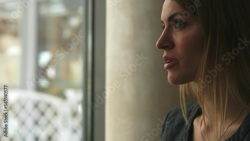 positivity, serenity - daydreaming woman looks out the window drinking coffee