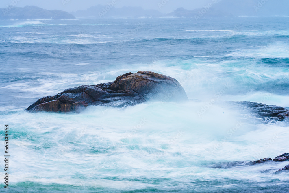 Fototapeta premium Waves crashing against cliffs during a winter storm.
