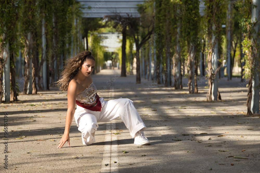 Latin and Hispanic girl, young and beautiful, dancing modern dance in the street outdoors. Dance concept, moonwalk, jumpstyle, shuffle, electrodance, hip hop, funky, popping. Latin and Hispanic girl, young and beautiful, dancing modern dance in the street outdoors. Dance concept, moonwalk, jumpstyle, shuffle, electrodance, hip hop, funky, popping.