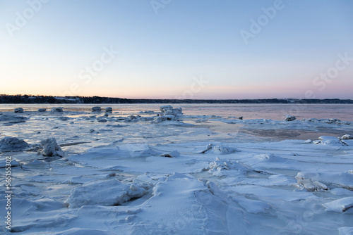 Blue hour view of the partly frozen St. Lawrence river and the south shore seen during a cold winter sunrise, Quebec City, Quebec, Canada © Anne Richard