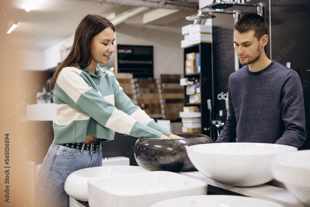 Obraz premium Woman with salesman choosing sink at warehouse