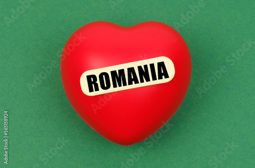 On a green surface lies a red heart with the inscription - Romania