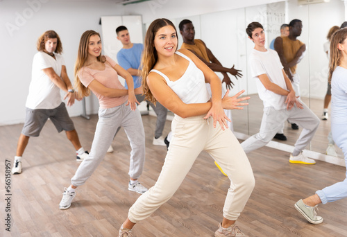 Group of energetic different people learning dance at dance class