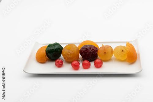 Plato con frutas confitadas, aislado en blanco
