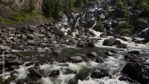 Aerial view of the cascading Uchar waterfall, flowing over rocks and forests photo