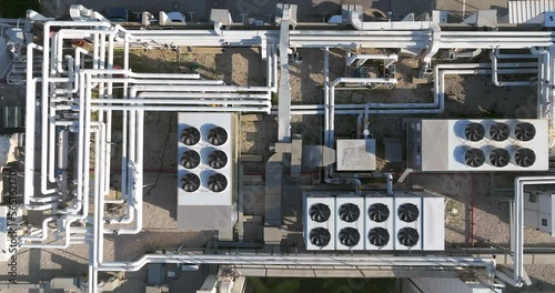 Industrial building rooftop with vents and pipes lined across, Top down view