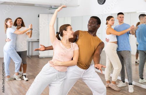 Couple male and girl rehearsing pair dance in dance studio