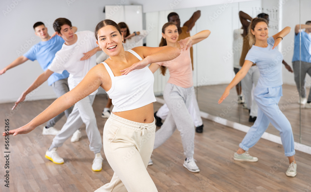 Happy active energetic multiracial dancers of different ages dancing aerobics at lesson in modern class studio