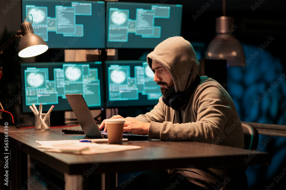 Hacker stealing computer information from server, cybercrime threat and security breach on multiple monitors. Programming virus and hacking big data hardware, man wearing hood.