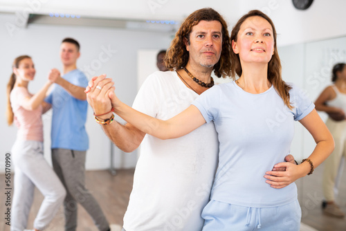 Woman and man practicing bachata dance moves in pair during group class