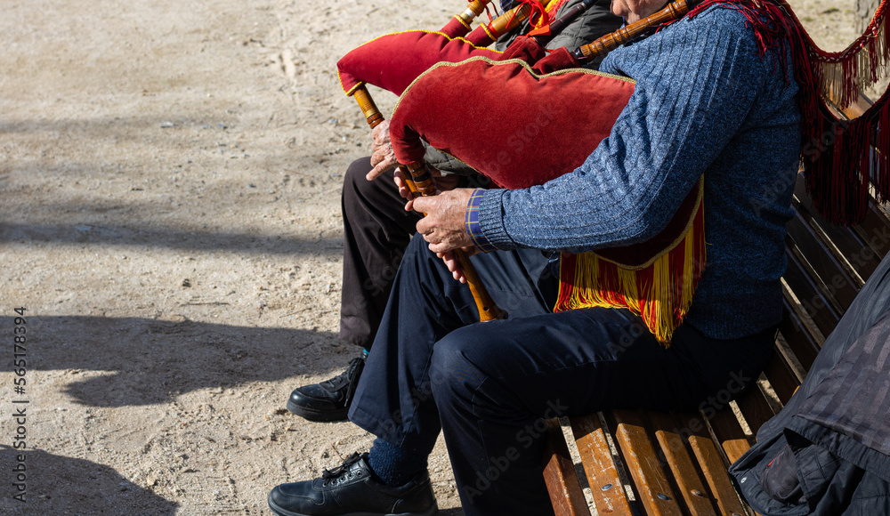 Pareja de señores mayores tocando la gaita sentados en un banco de ...