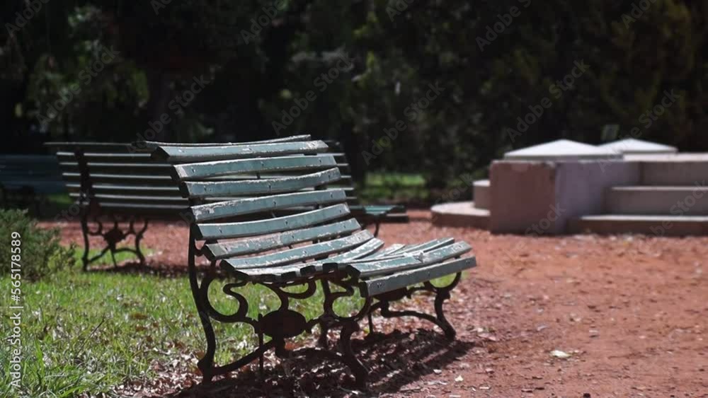 Personas pasando frente a un banco solitario en una plaza o parque común Personas pasando frente a un banco solitario en una plaza o parque común