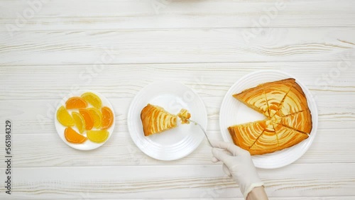 Cottage cheese casserole with pumpkin in a white plate on a white wooden table. Striped casserole with cheese and pumpkin. Chef cuts and taste the cheese pumpkin cake.