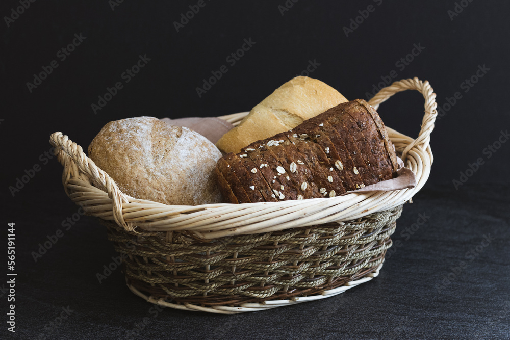 Three different types of bread in a wicker basket.
