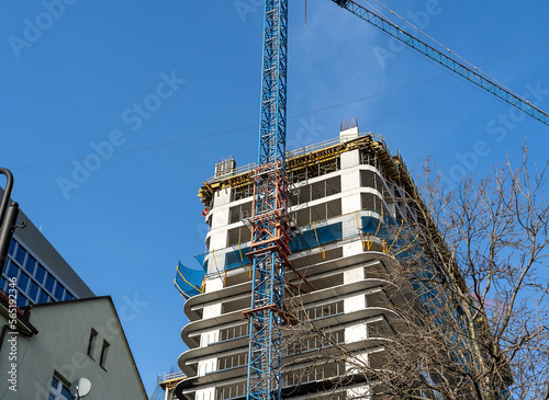 Construction site with cranes against blue sky. Industrial background. Modern skyscrapers. Unfinished construction 