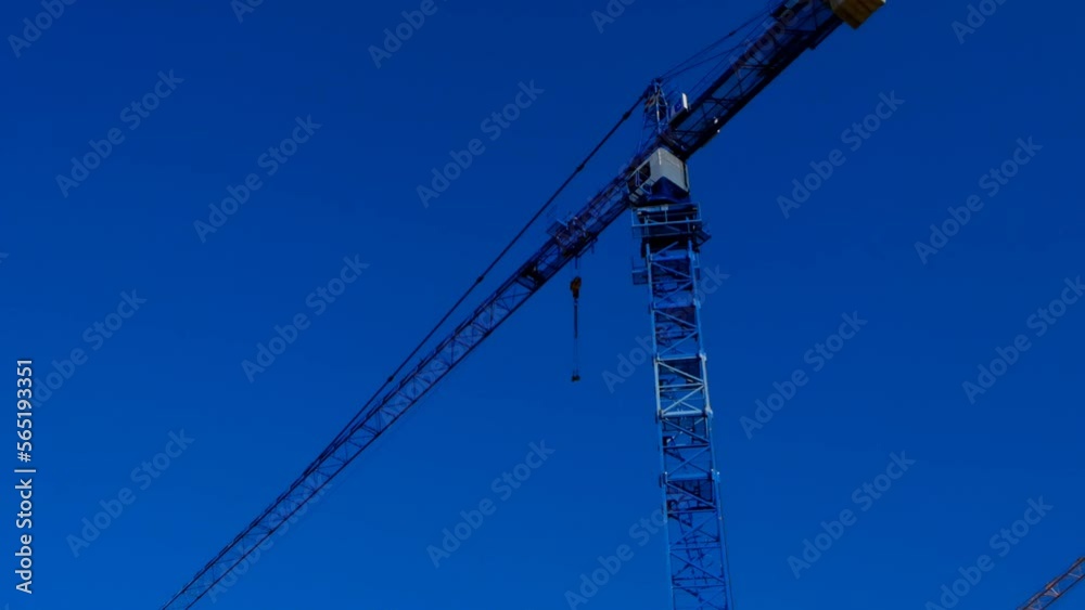 Building.Construction crane. Construction machinery on blue sky background. New house construction. 4k footage Building.Construction crane. Construction machinery on blue sky background. New house construction. 4k footage