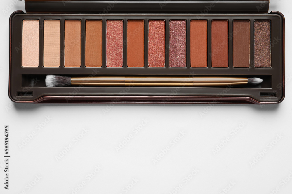 Beautiful eye shadow palette with brush on white table, top view. Space for text Beautiful eye shadow palette with brush on white table, top view. Space for text