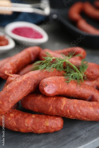 Delicious sausages and dill on grey table, closeup