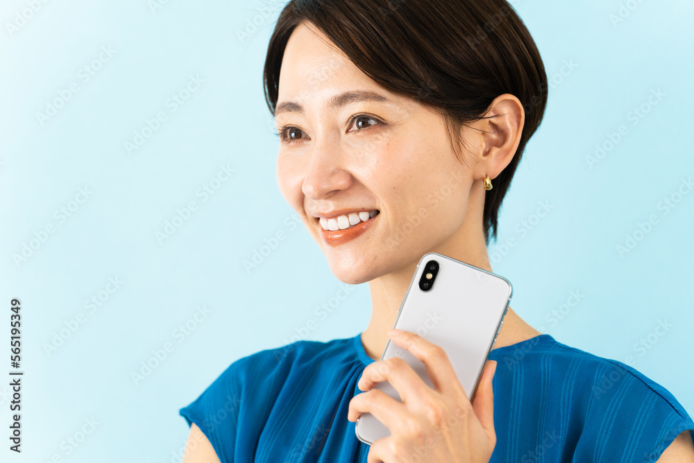 スマートフォンを使うワンピースを着た若い女性 スマートフォンを使うワンピースを着た若い女性