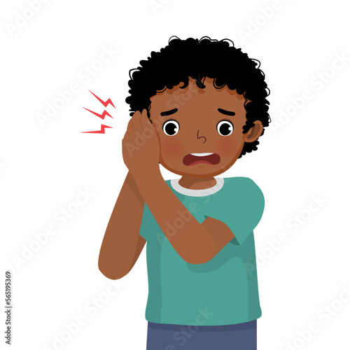 Cute little African boy has earache holding his ear because of infection, inflammation, feeling painful inside