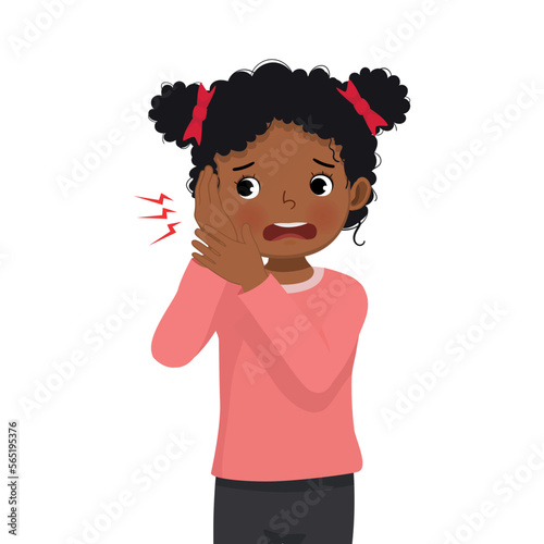 Cute little African girl has earache holding her ear because of infection, inflammation, feeling painful inside