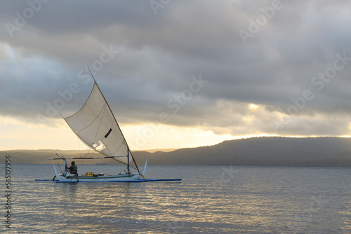 Fisherman sailing at dawn. fisherman on a wooden boat at sunrise