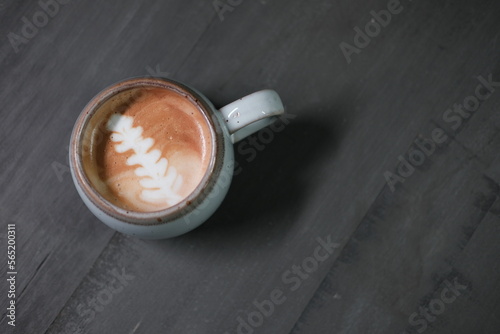 Cup of coffee on grey background. Place for texte. Top view of latte art coffee, on Gray abstract wooden background.