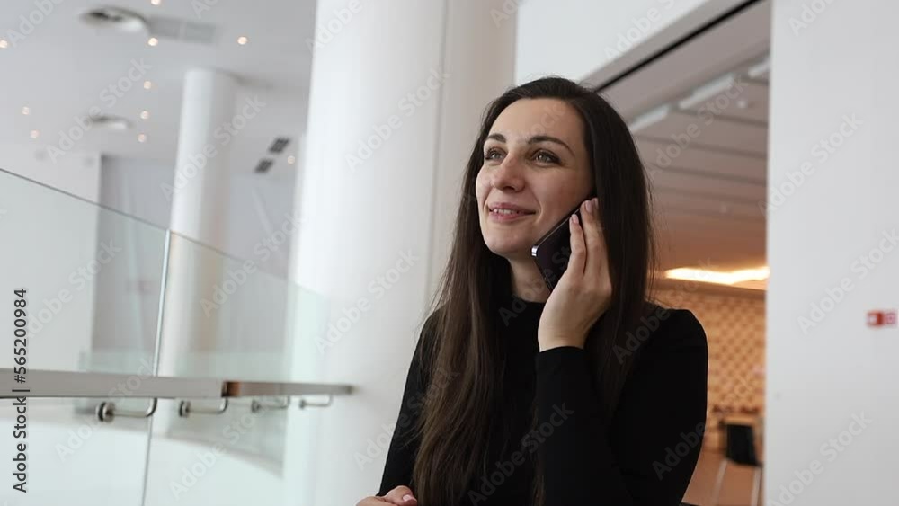 Beautiful woman talking on the phone in a business center. Account manager, freelancer outside the home. Beautiful woman talking on the phone in a business center. Account manager, freelancer outside the home.