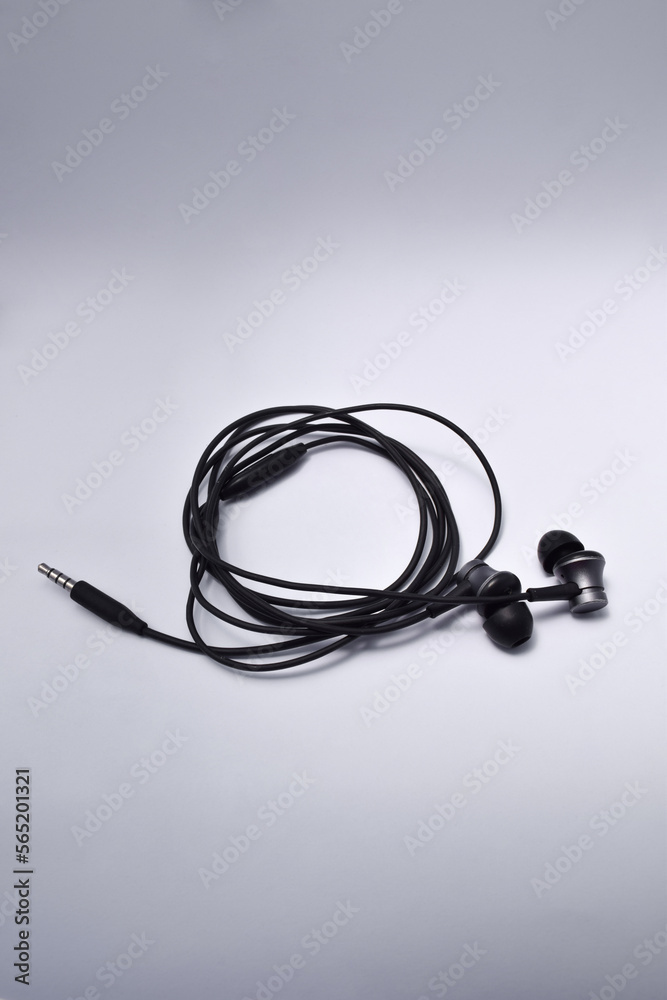 Music earphones. Black stereo audio headphone, electronic personal small portable sound earbud, isolated on white background Music earphones. Black stereo audio headphone, electronic personal small portable sound earbud, isolated on white background