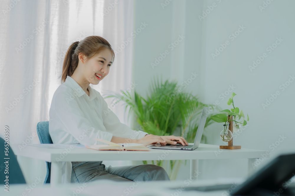Pretty smiling asian female accountant working on laptop computer in modern office Accounting analysis report, finance and tax system concept Pretty smiling asian female accountant working on laptop computer in modern office Accounting analysis report, finance and tax system concept