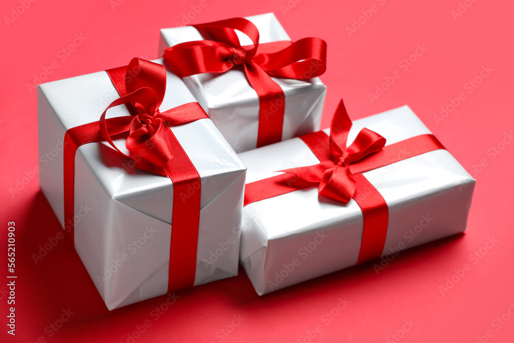 Obraz premium Gift boxes with beautiful bows on red background. Valentine's Day celebration