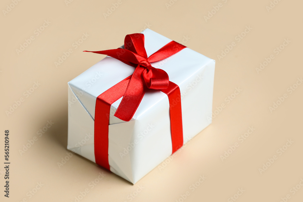 Gift box with beautiful bow on beige background. Valentine's Day celebration Gift box with beautiful bow on beige background. Valentine's Day celebration