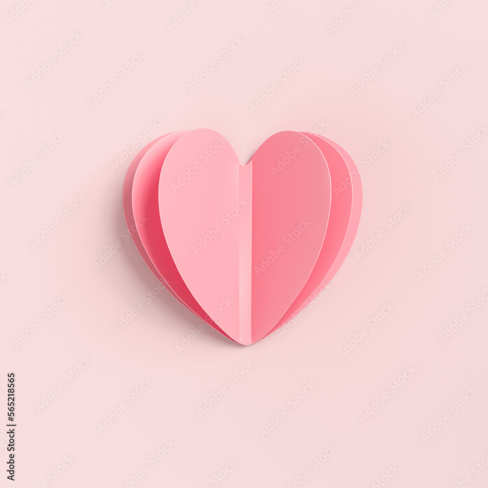 Pink paper heart on pink colored background. Minimal style valentine card or wedding invitation. Beautiful cute heart on pastel color table flat lay composition. Valentines Day greeting card concept