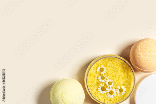 Top view bath bombs and sea salt with  herbal extract of chamomile  spa products close up. Natural cosmetic for beauty treatment and body care  home care  herbal medicine  beige background