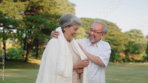 Asian senior couple wears or cover a blanket in the public garden, Elderly retirement family taking care of each other and outdoor concept