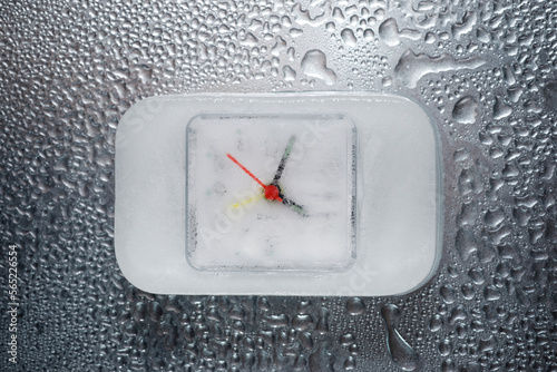 Overhead view of frozen clock on wet table photo