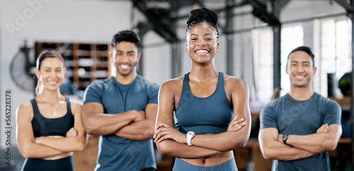 Fitness, portrait and woman personal trainer with a team standing with crossed arms in the gym. Sports, collaboration and happy people after exercise, workout or training class in sport studio.