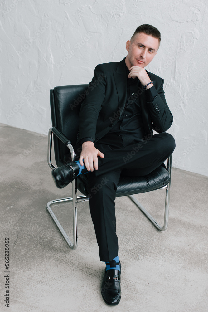 Stylish beautiful photo session in a photo studio of a luxurious couple in a black suit and black dress, where a girl with red hair. They hug. Stylish beautiful photo session in a photo studio of a luxurious couple in a black suit and black dress, where a girl with red hair. They hug.