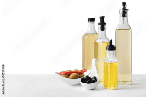 Bottles of different cooking oils and olives on white background