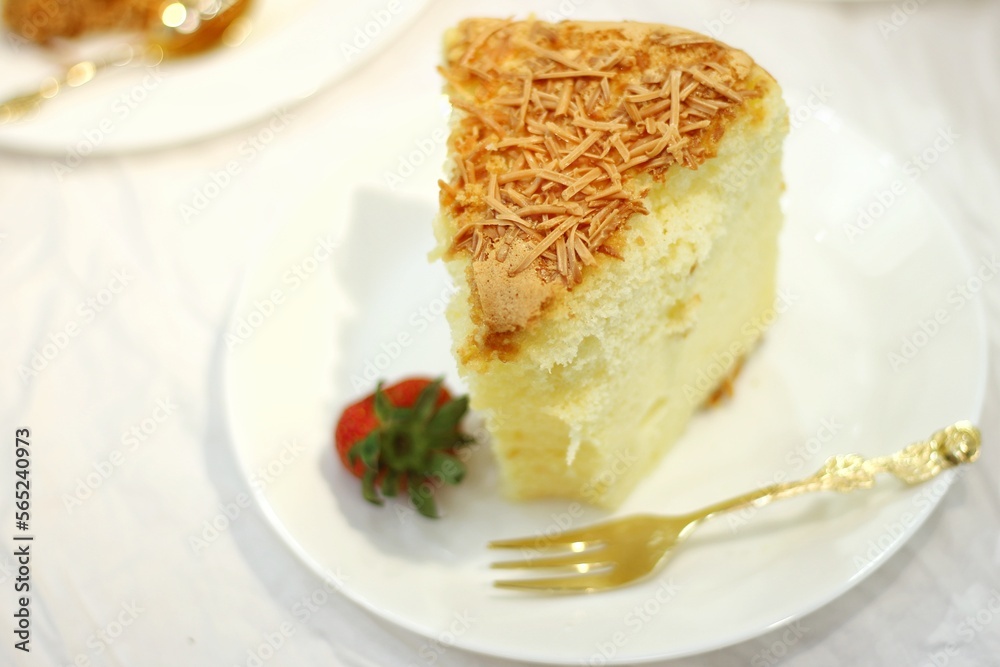 a piece of sponge cake with strawberries on a white plate. soft and delicious cheese cake. homemade bakery concept for background or wallpaper. a piece of sponge cake with strawberries on a white plate. soft and delicious cheese cake. homemade bakery concept for background or wallpaper.