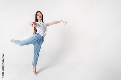 A teenage girl in jeans and a white T-shirt performs dance moves. White background