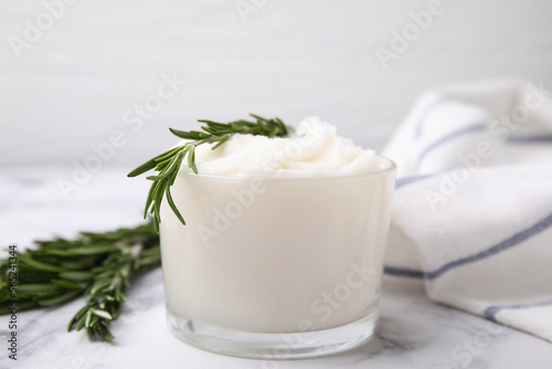 Fotografija Delicious pork lard with rosemary in glass on white marble table, closeup